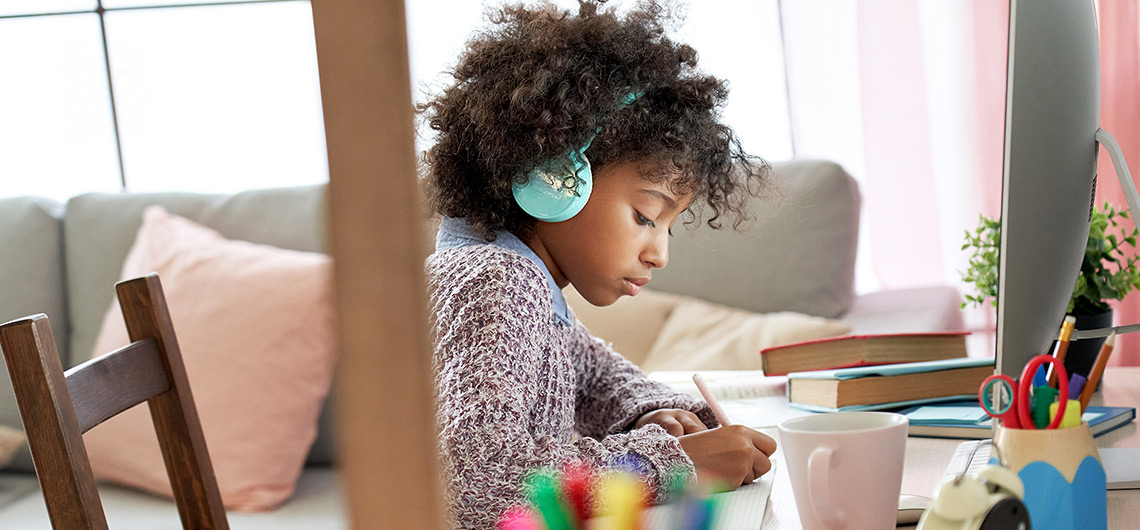 criança a estudar de headphones